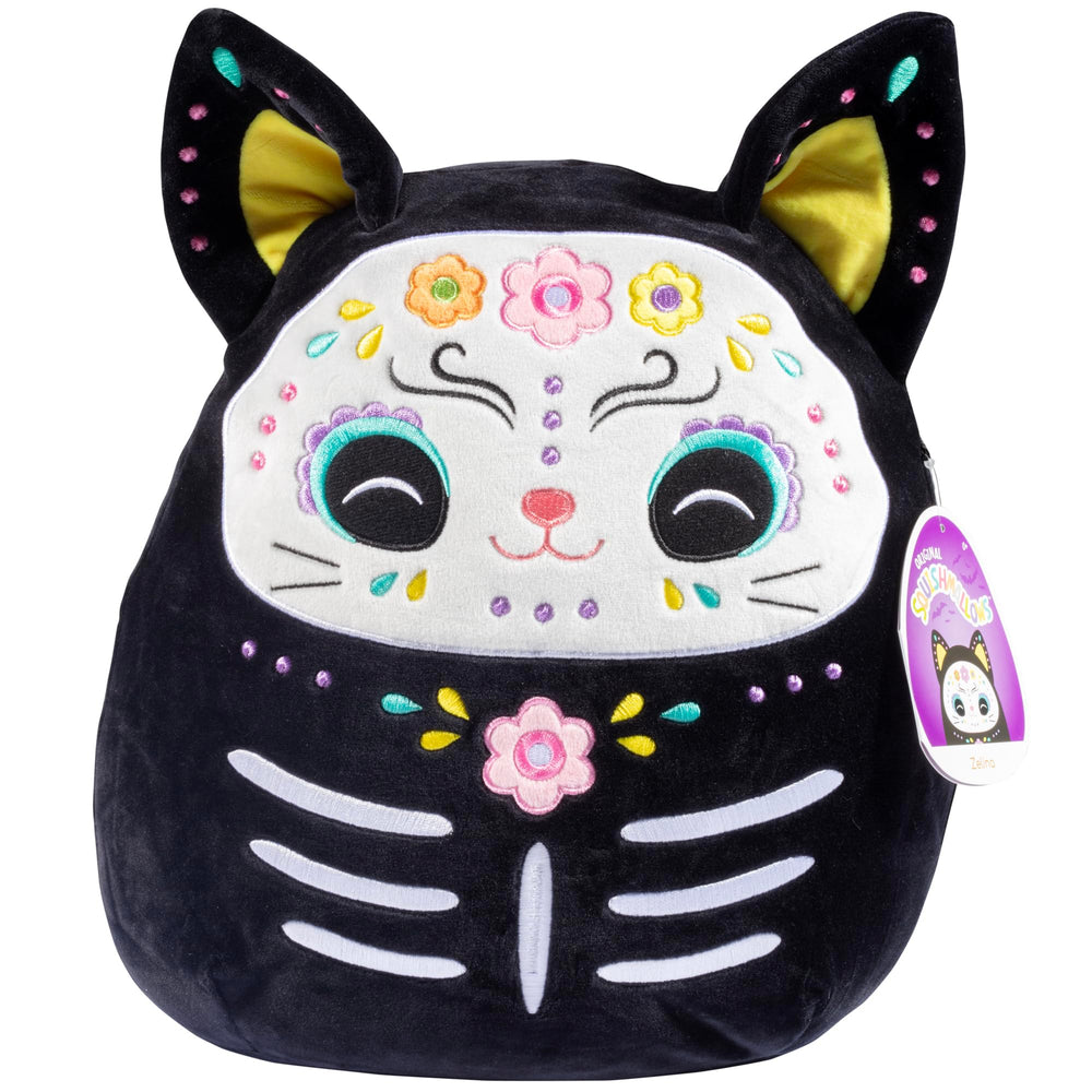 Squishmallows Zelina Day of the Dead Cat perched on a shelf for seasonal cuddles.