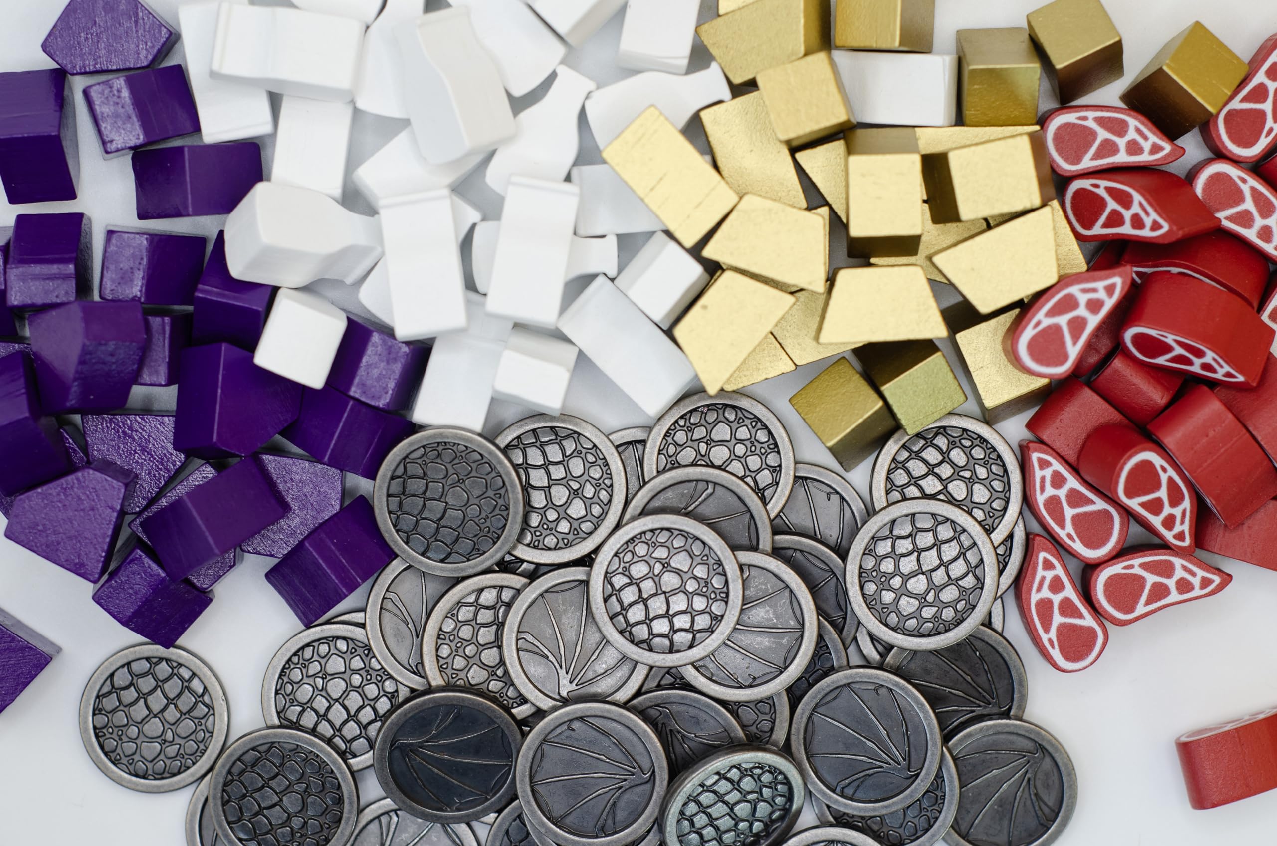 Stonemaier Wyrmspan metal coins close-up highlighting dragon motifs and shine