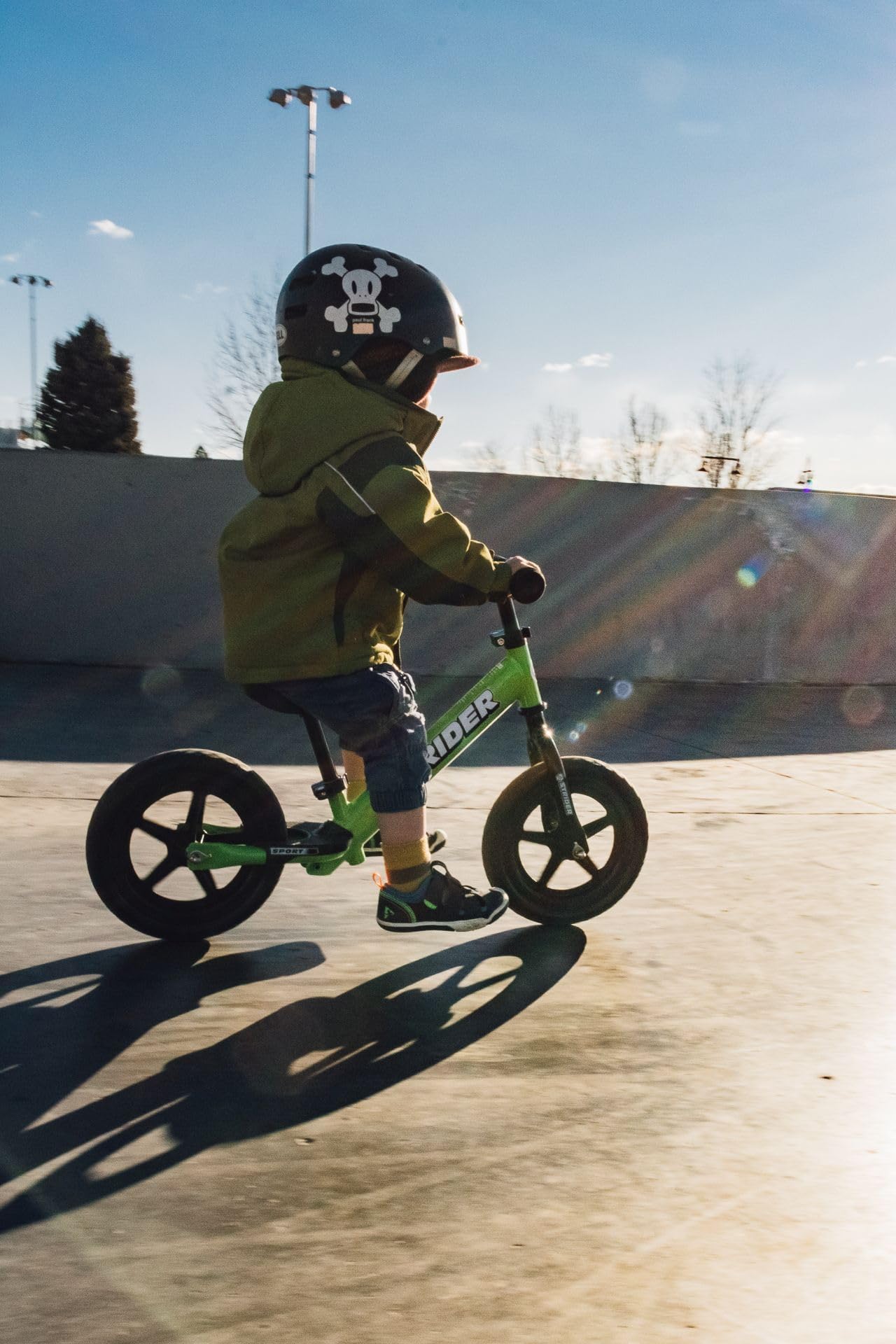 Strider child riding balance bike to illustrate early balance practice.