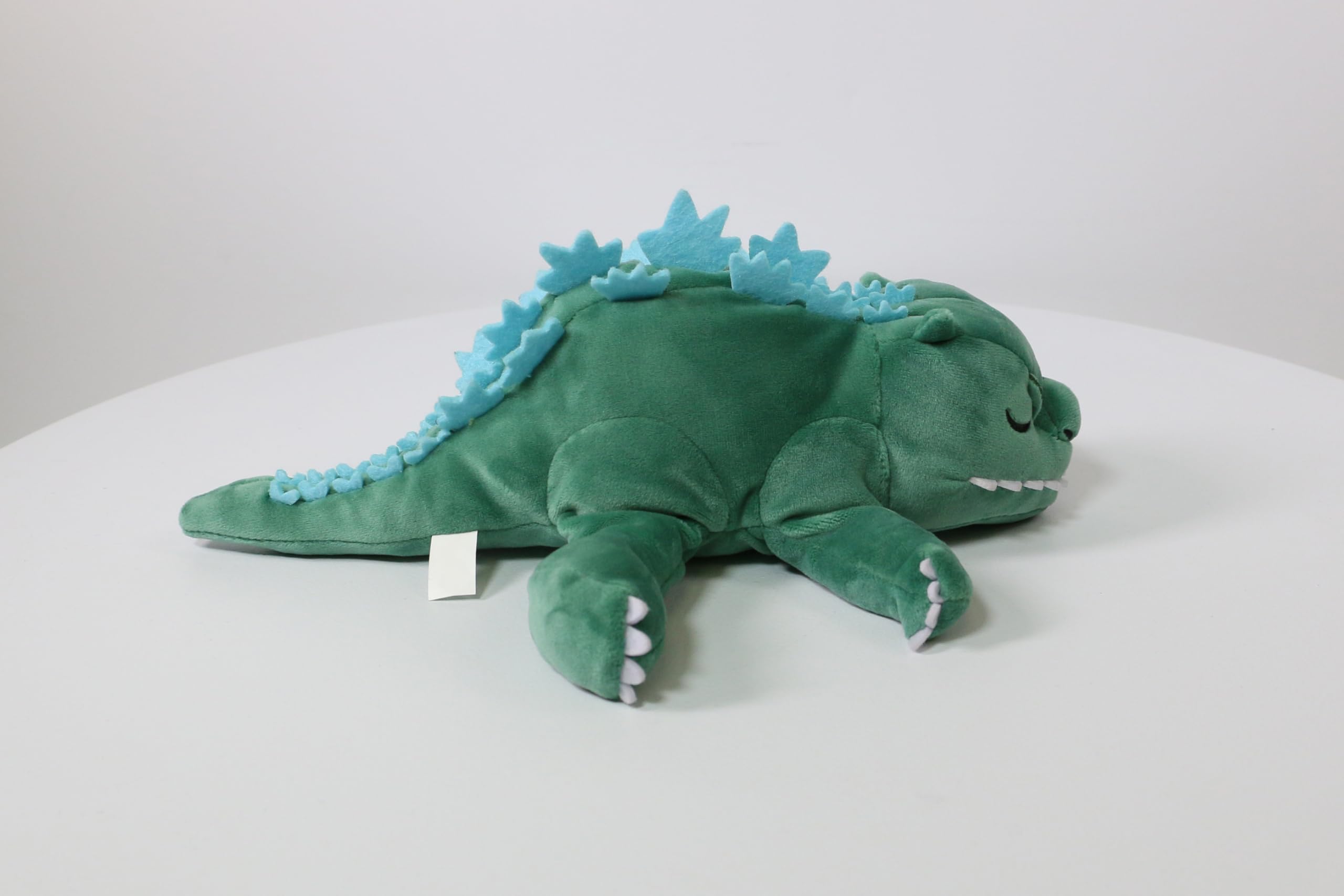 Surreal Entertainment Godzilla plush sleeping expression highlights cozy bedtime companion.