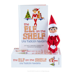 The Elf on the Shelf blue-eyed girl scout elf beside the Spanish book inspires family Christmas tradition