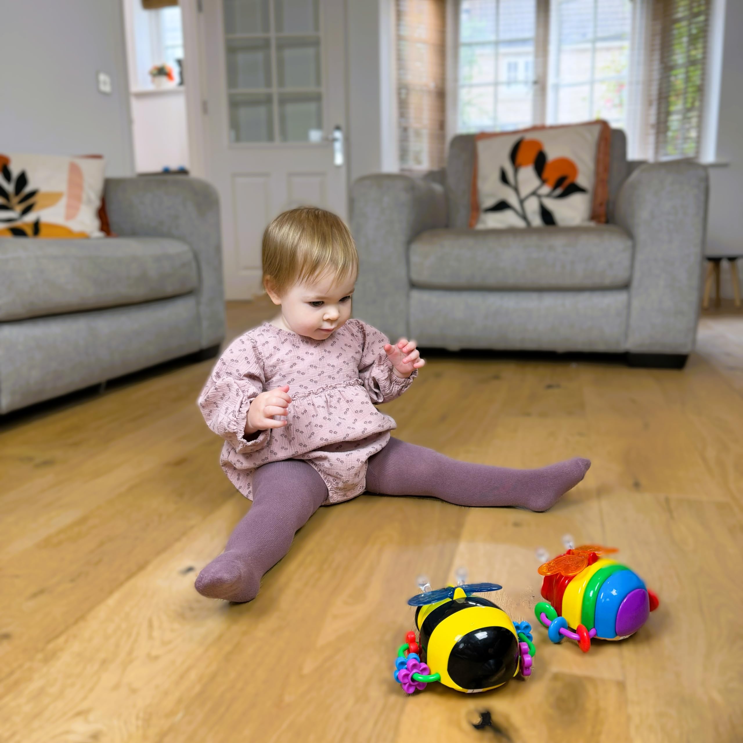 The Learning Journey butterfly beside baby hand showing compact size and safe design