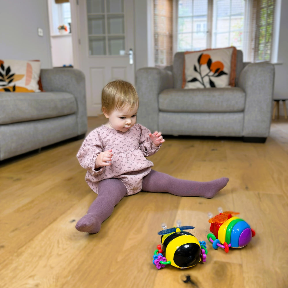 The Learning Journey butterfly beside baby hand showing compact size and safe design