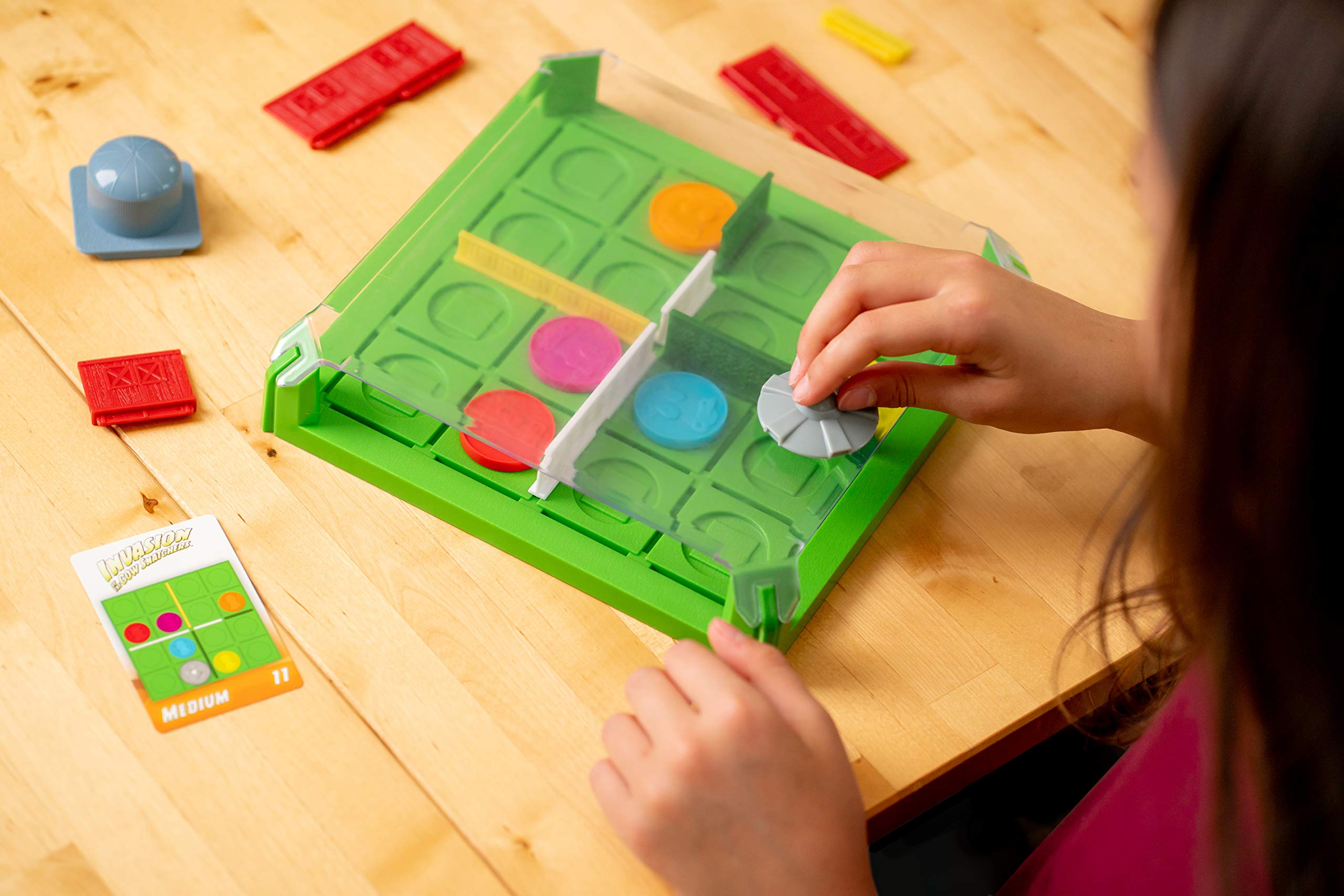 ThinkFun Invasion of the Cow Snatchers magnetic tokens engage fine motor skills during placement.
