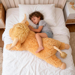 Large yellow Highland Cow pillow displayed on bed for decor