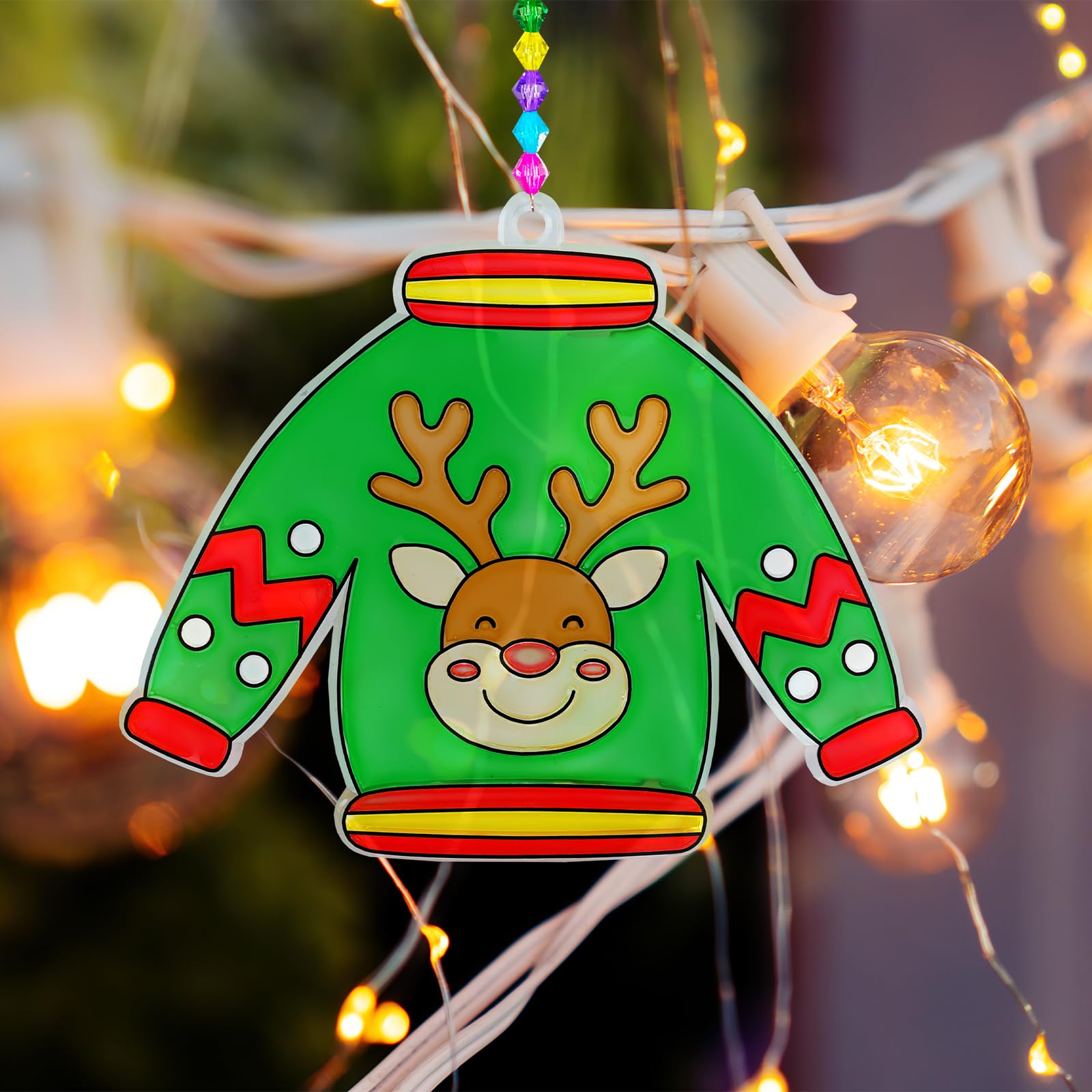Finished Winlyn Ugly Sweater suncatchers on a sunny window illuminate cheerful holiday hues