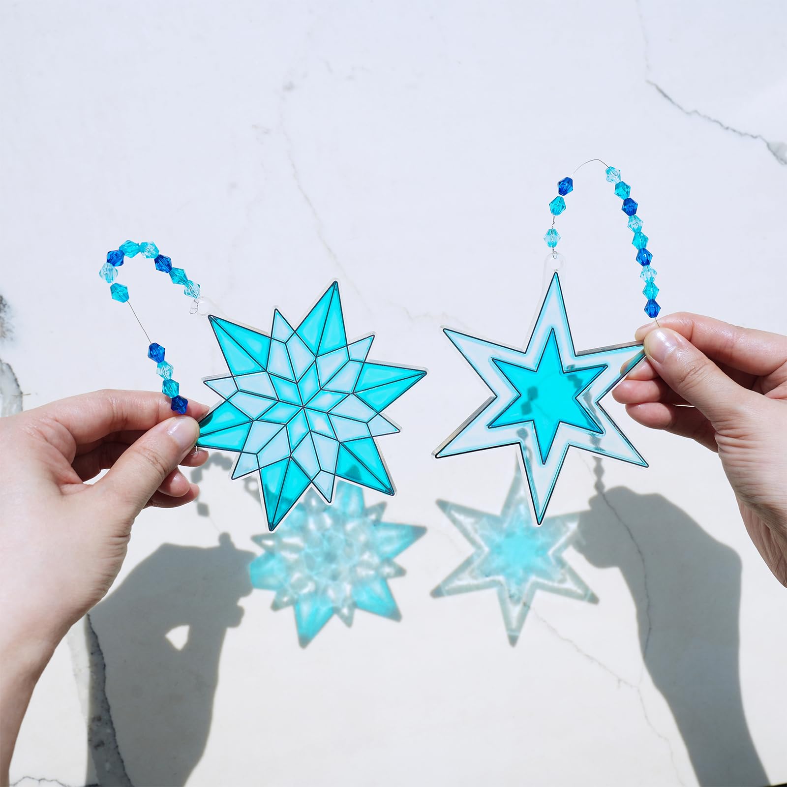 Winlyn painted snowflake suncatcher catching sunlight with a glossy translucent finish.