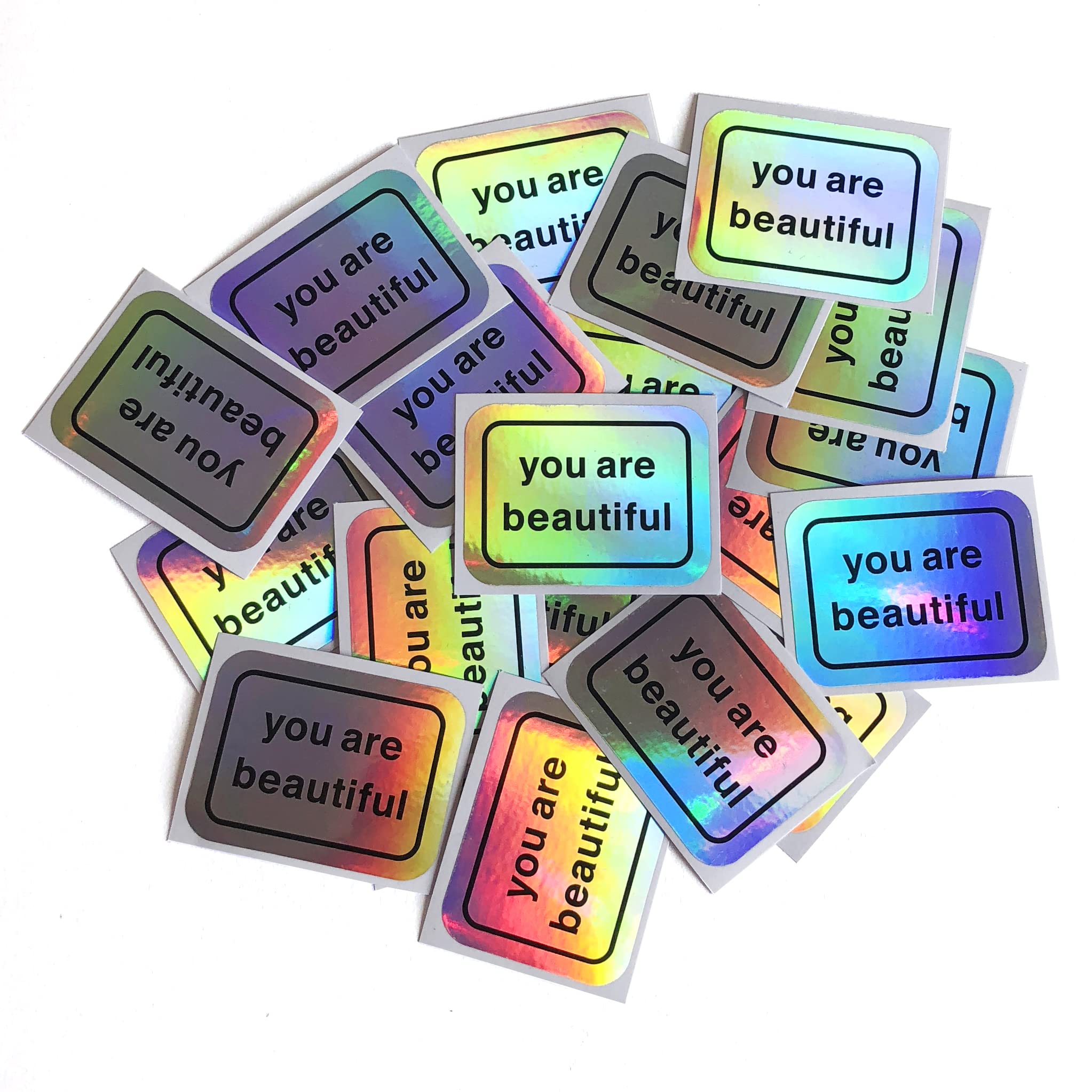 You Are Beautiful holographic sticker pack cover shot with rainbow shine on a notebook